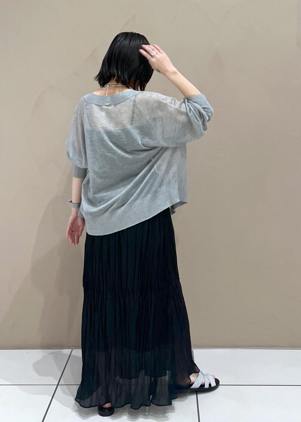 シルバー系のサンダル、ブラック系のスカート、グレー系のカーディガン/ボレロを着用したレディースの春コーディネートの4枚目の写真