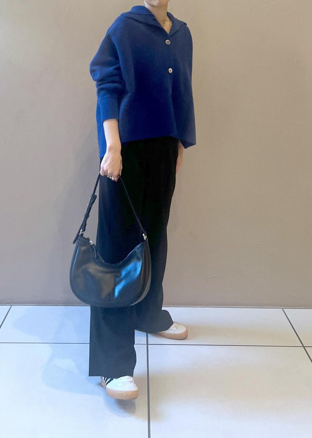 ホワイト系のスニーカー、ブルー系のカーディガン/ボレロ、ブラック系のその他パンツを着用したレディースの秋コーディネートの9枚目の写真