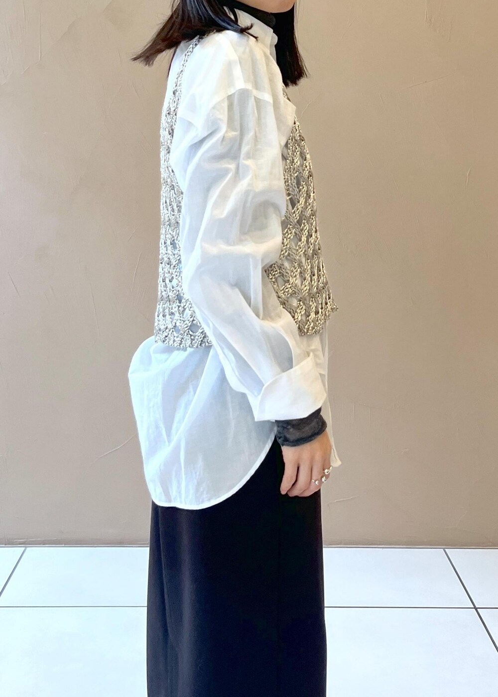 ブラック系のスカート、シルバー系のベスト、ホワイト系のシャツ/ブラウスを着用したレディースの秋コーディネートの5枚目の写真