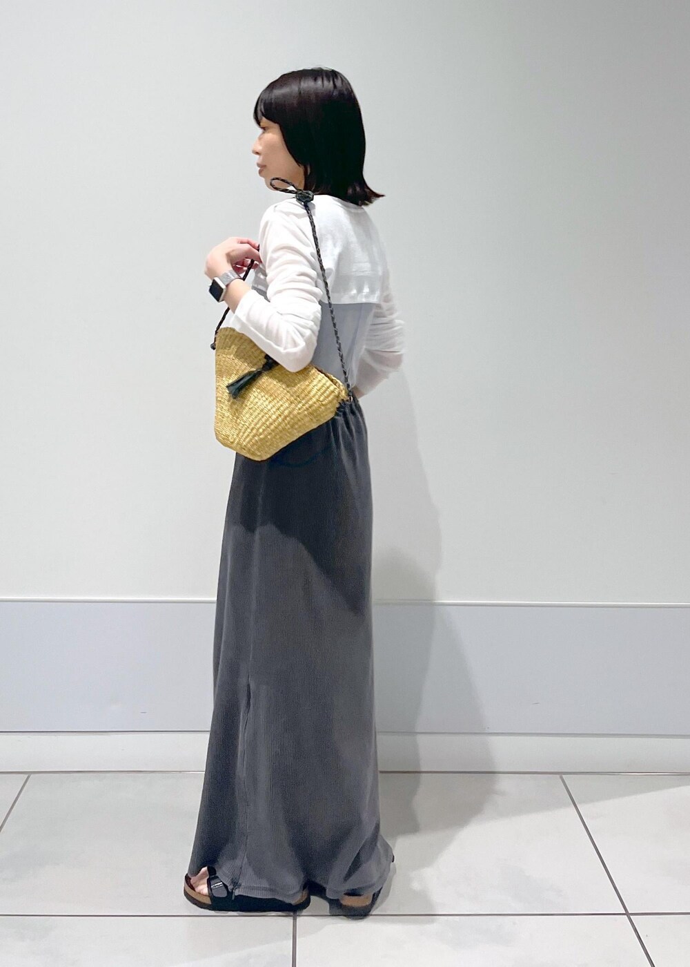 ベージュ系のかごバッグ、グレー系のスカート、グレー系のタンクトップを着用したレディースの夏コーディネートの2枚目の写真