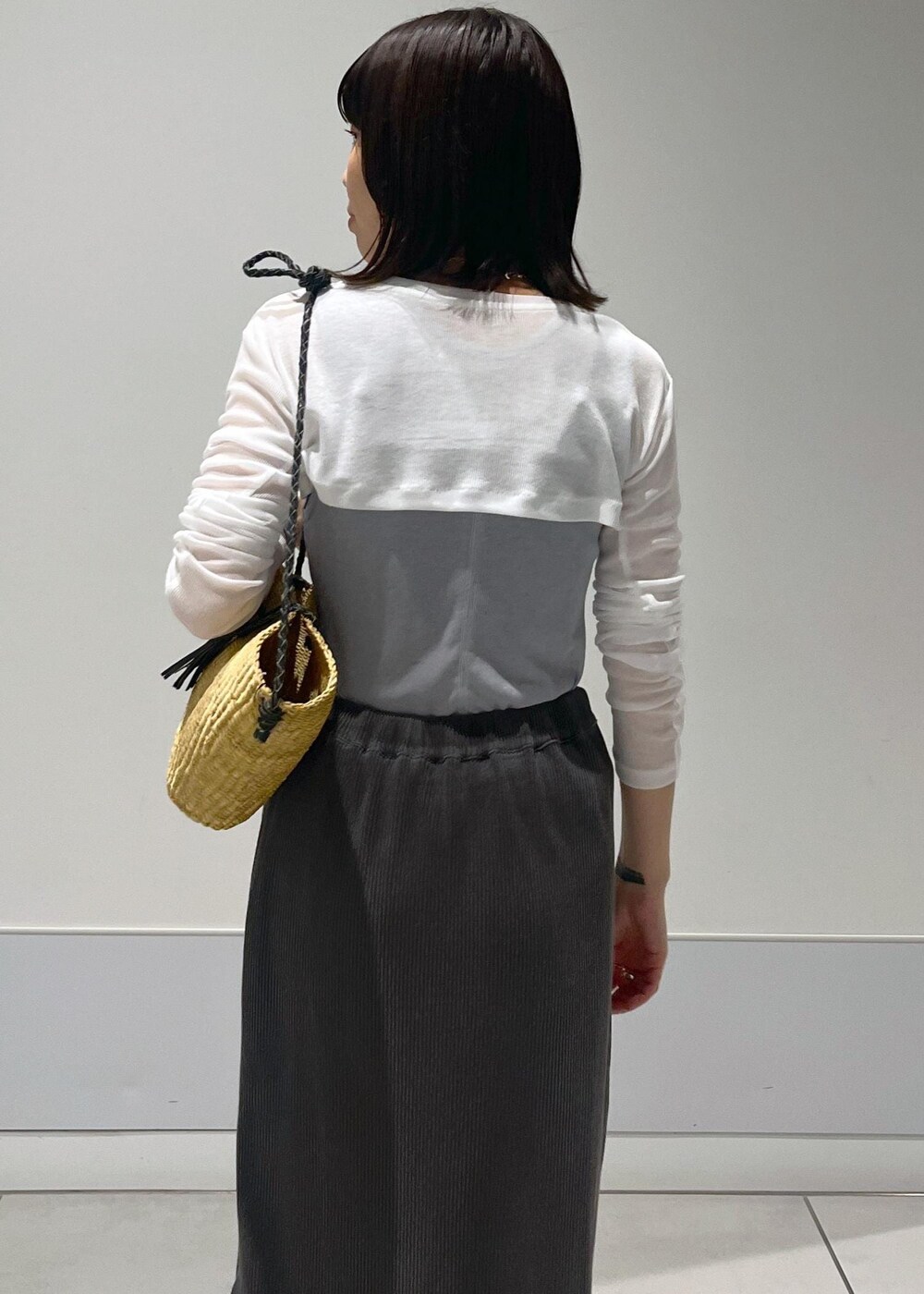 ベージュ系のかごバッグ、グレー系のスカート、グレー系のタンクトップを着用したレディースの夏コーディネートの5枚目の写真