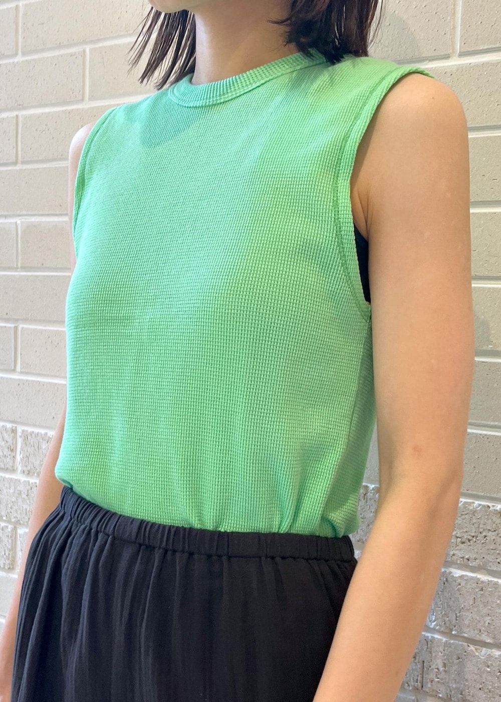 グリーン系のTシャツ/カットソー、ブラック系のスカート、ブラック系のトートバッグを着用したレディースの春コーディネートの4枚目の写真