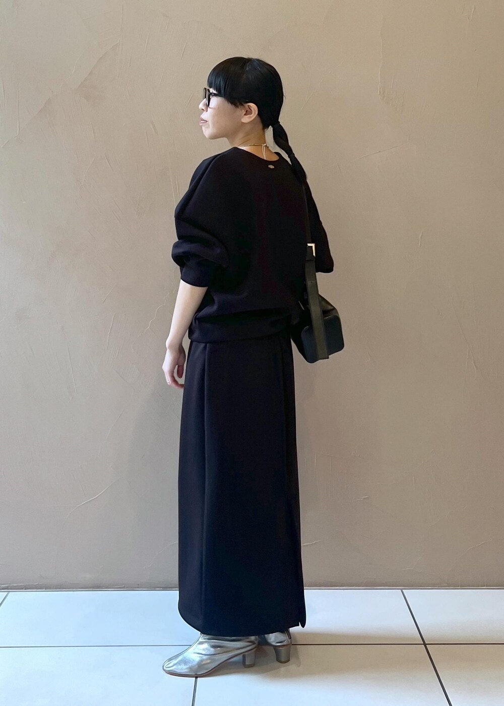 ブラック系のショルダーバッグ、ブラック系のスカート、ブラック系のTシャツ/カットソーを着用したレディースの秋コーディネートの8枚目の写真