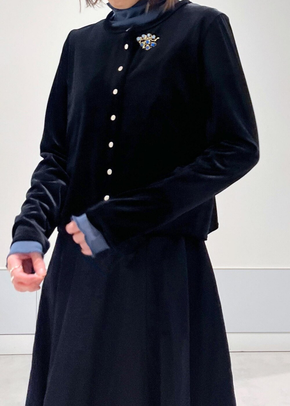 ブルー系のTシャツ/カットソー、ブラック系のスカート、ブラック系のカーディガン/ボレロを着用したレディースの冬コーディネートの4枚目の写真