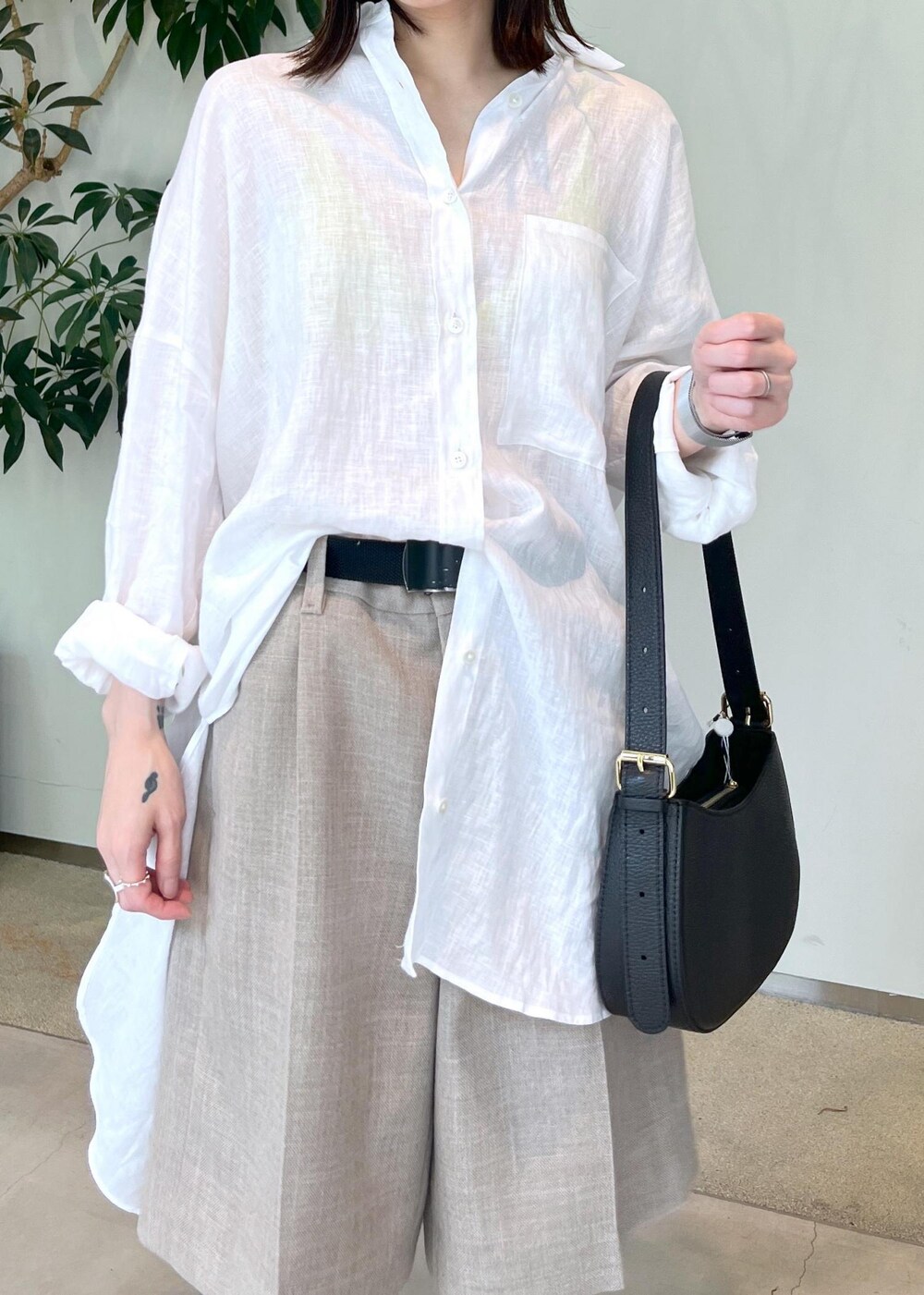 ベージュ系のその他パンツ、ブラック系のサンダル、ホワイト系のシャツ/ブラウスを着用したレディースの夏コーディネートの5枚目の写真