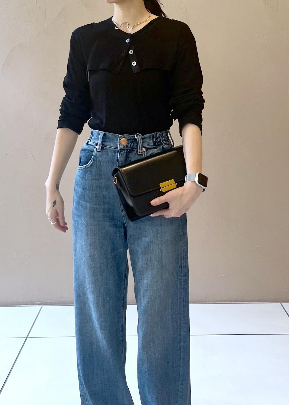 ブルー系のデニムパンツ、ブラック系のショルダーバッグ、ブラック系のカーディガン/ボレロを着用したレディースの夏コーディネートの4枚目の写真