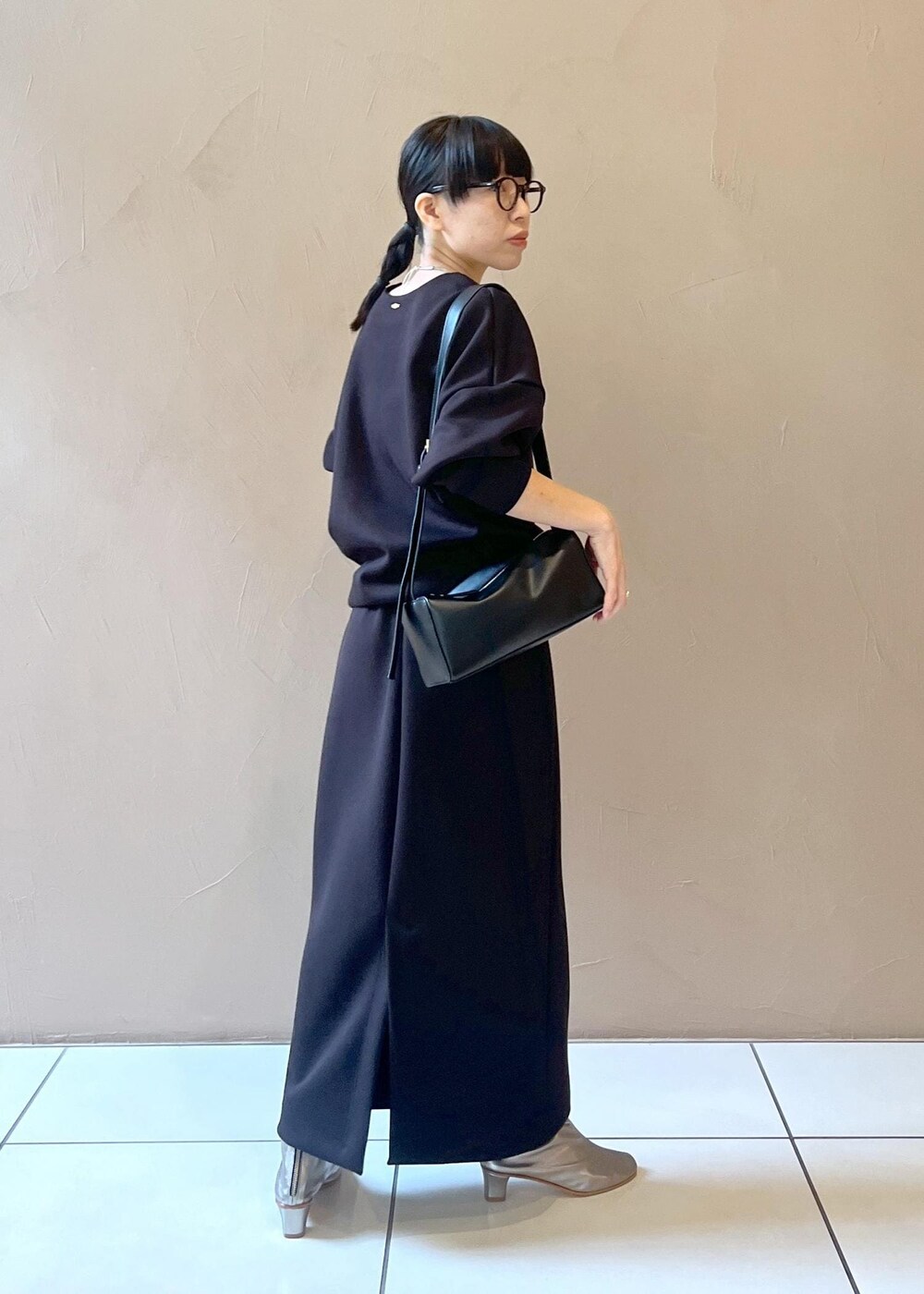 ブラック系のショルダーバッグ、ブラック系のスカート、ブラック系のTシャツ/カットソーを着用したレディースの秋コーディネートの4枚目の写真