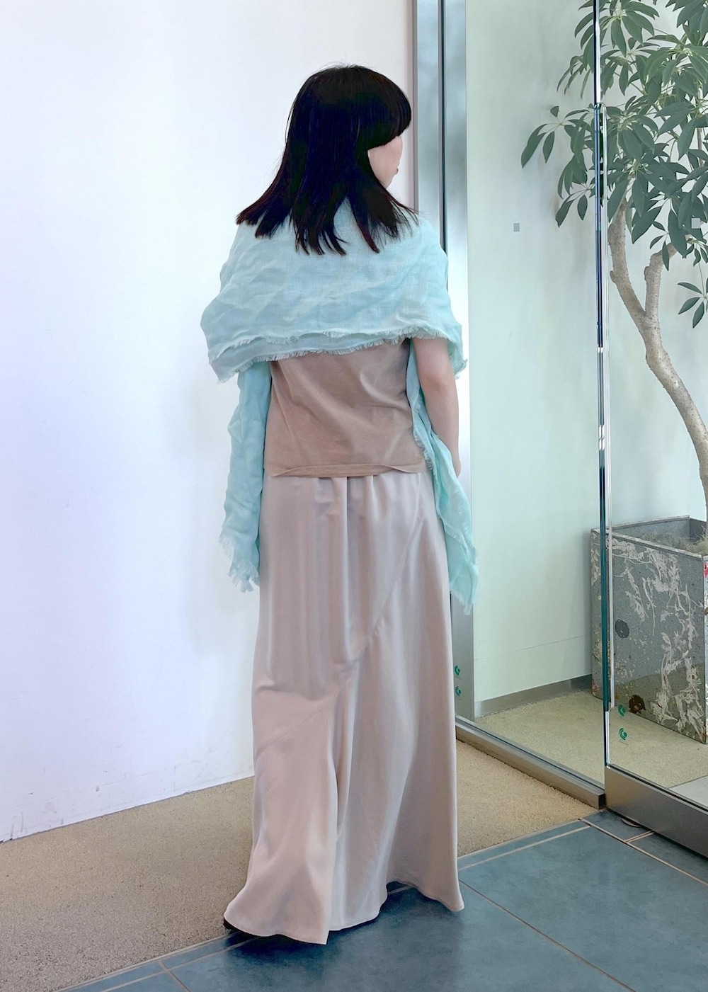 ベージュ系のスカート、ベージュ系のタンクトップ、グリーン系のストール/ショールを着用したレディースの夏コーディネートの2枚目の写真