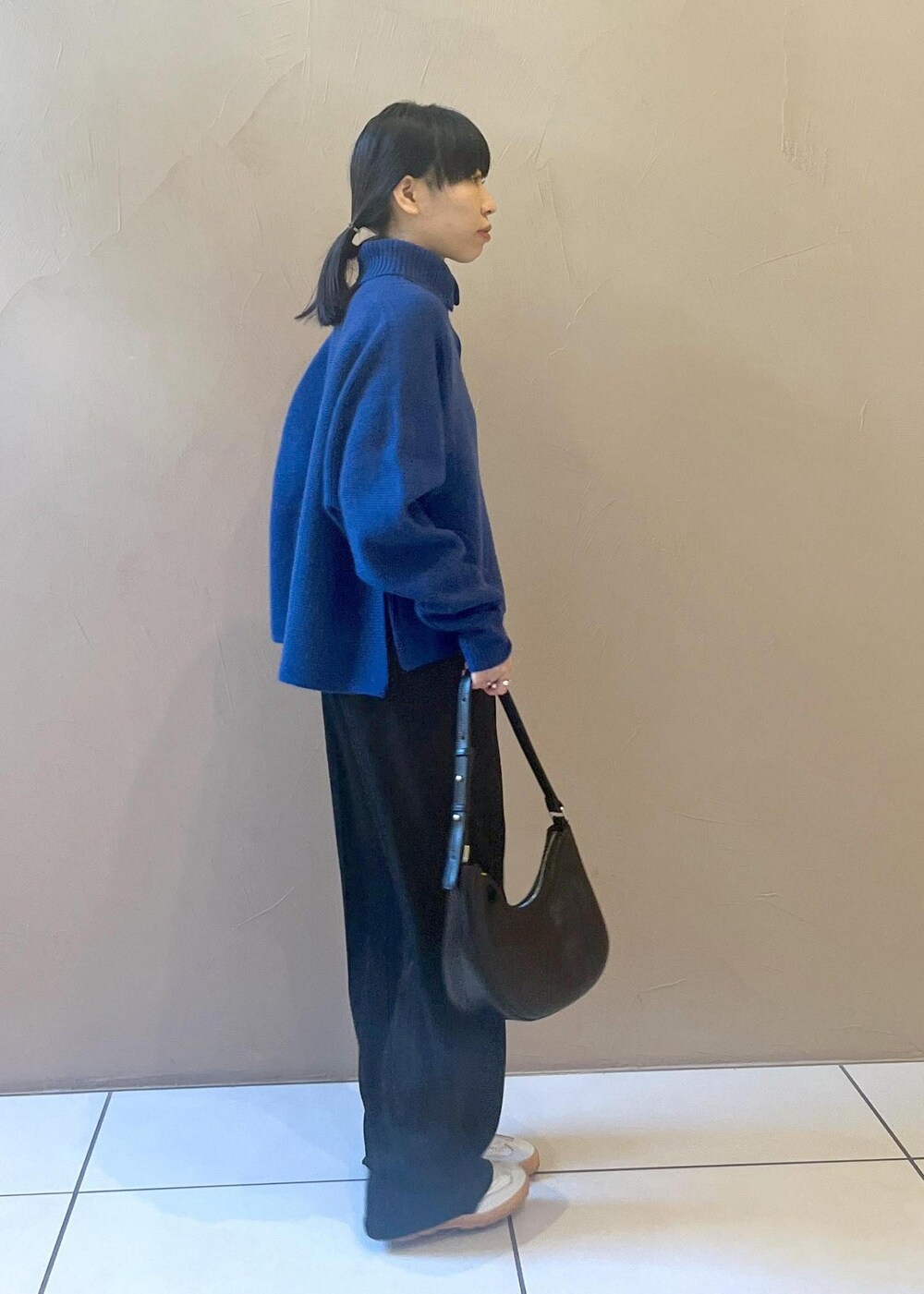 ホワイト系のスニーカー、ブルー系のカーディガン/ボレロ、ブラック系のその他パンツを着用したレディースの秋コーディネートの5枚目の写真