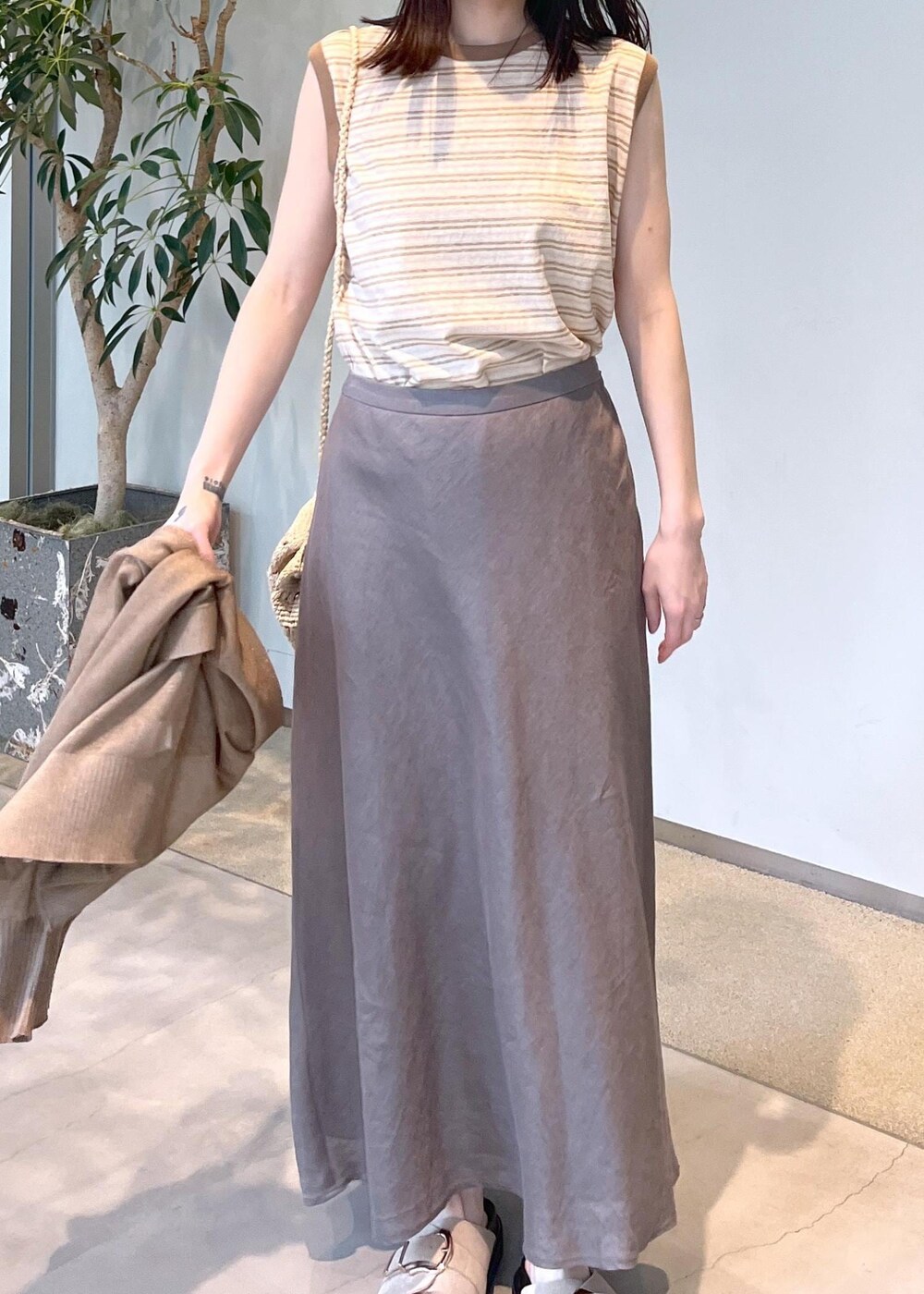 ベージュ系のサンダル、グレー系のスカート、ゴールド系のカーディガン/ボレロを着用したレディースの春コーディネートの9枚目の写真