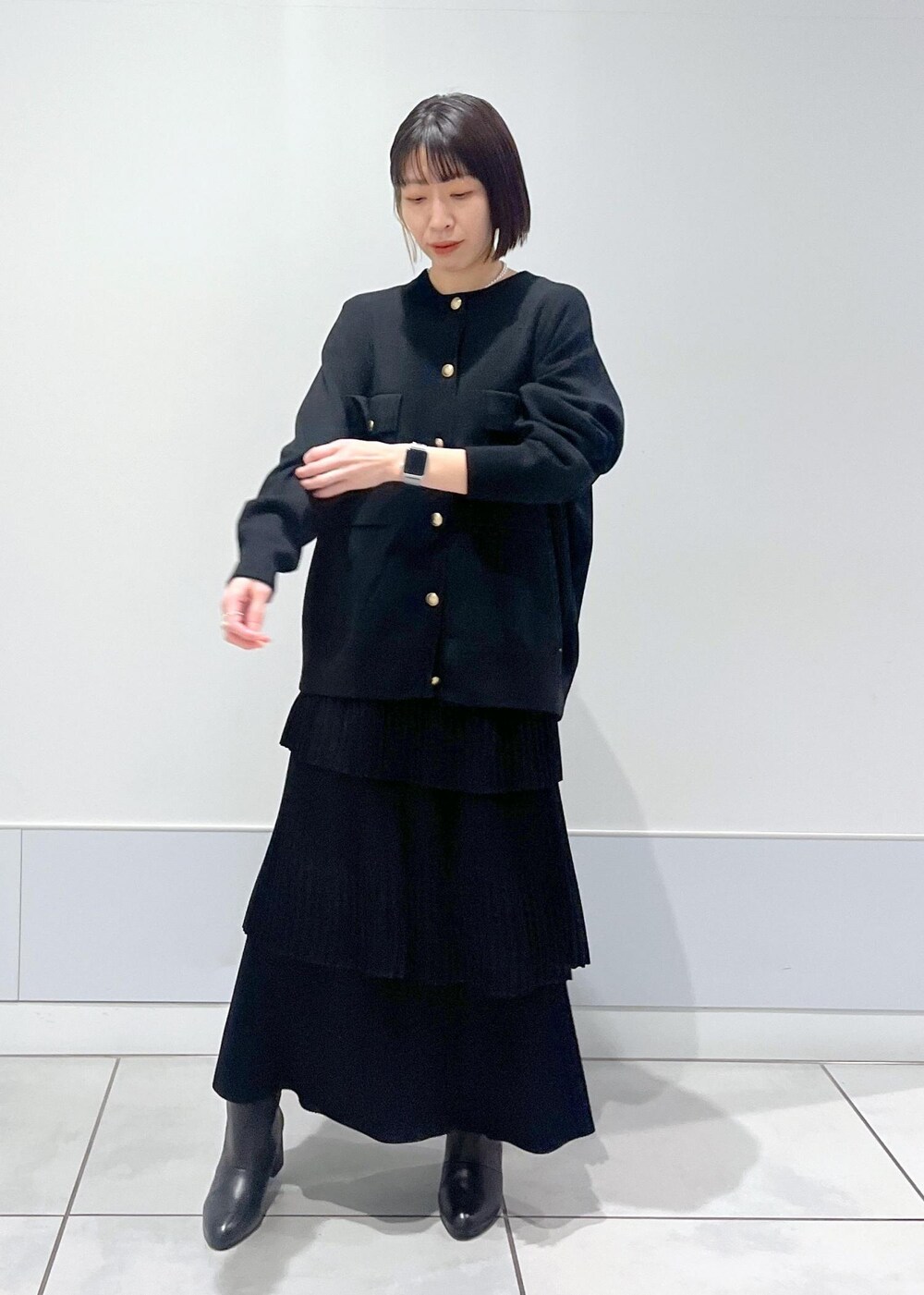 ブラック系のブーツ、ブラック系のカーディガン/ボレロ、ブラック系のスカートを着用したレディースの冬コーディネートの4枚目の写真