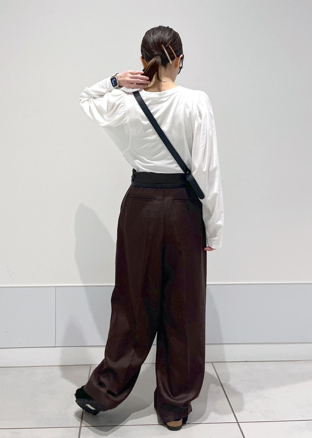 ホワイト系のTシャツ/カットソー、ブラウン系のスラックス、ブラック系のボディバッグ/ウエストポーチを着用したレディースの秋コーディネートの2枚目の写真