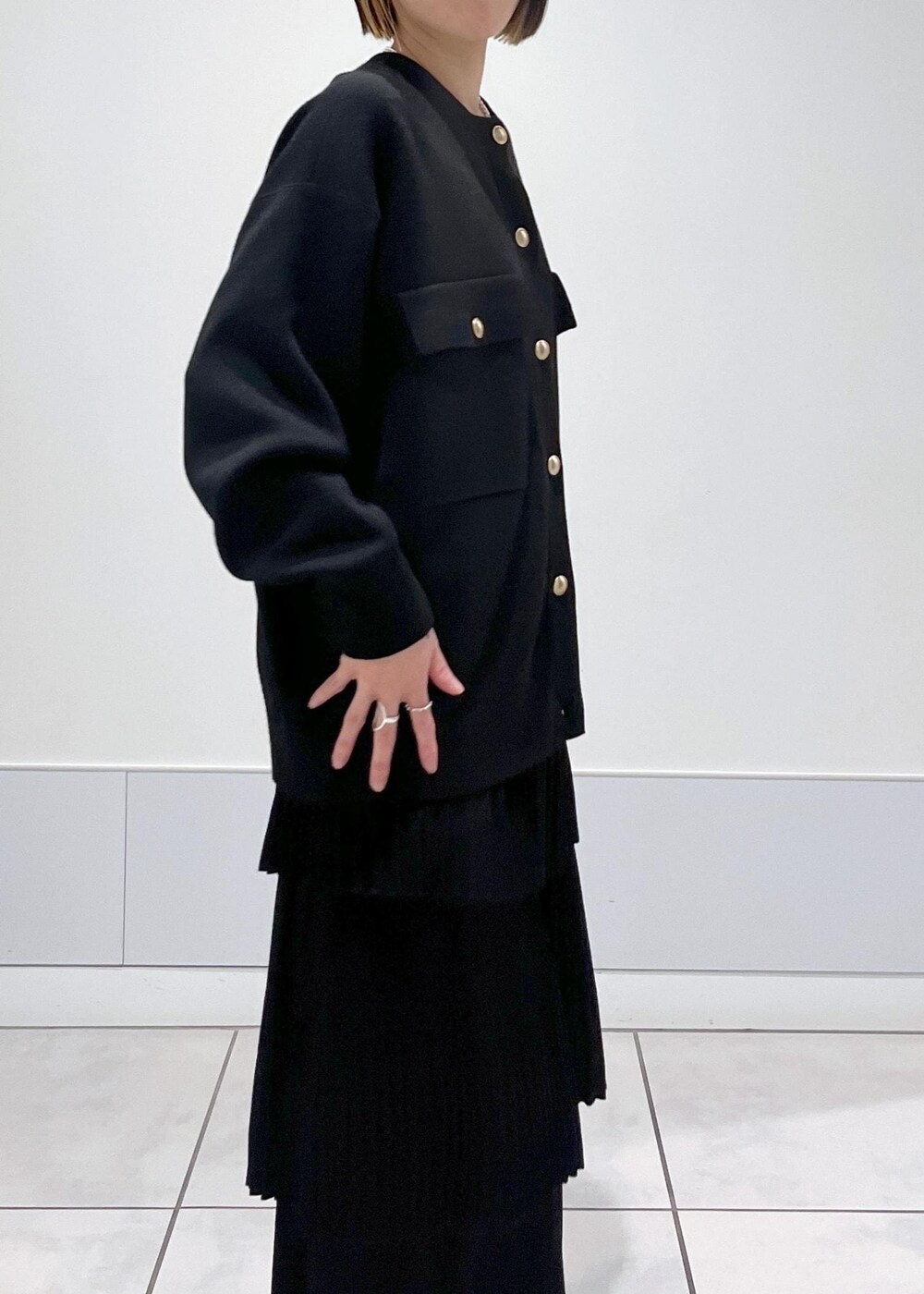 ブラック系のブーツ、ブラック系のカーディガン/ボレロ、ブラック系のスカートを着用したレディースの冬コーディネートの5枚目の写真