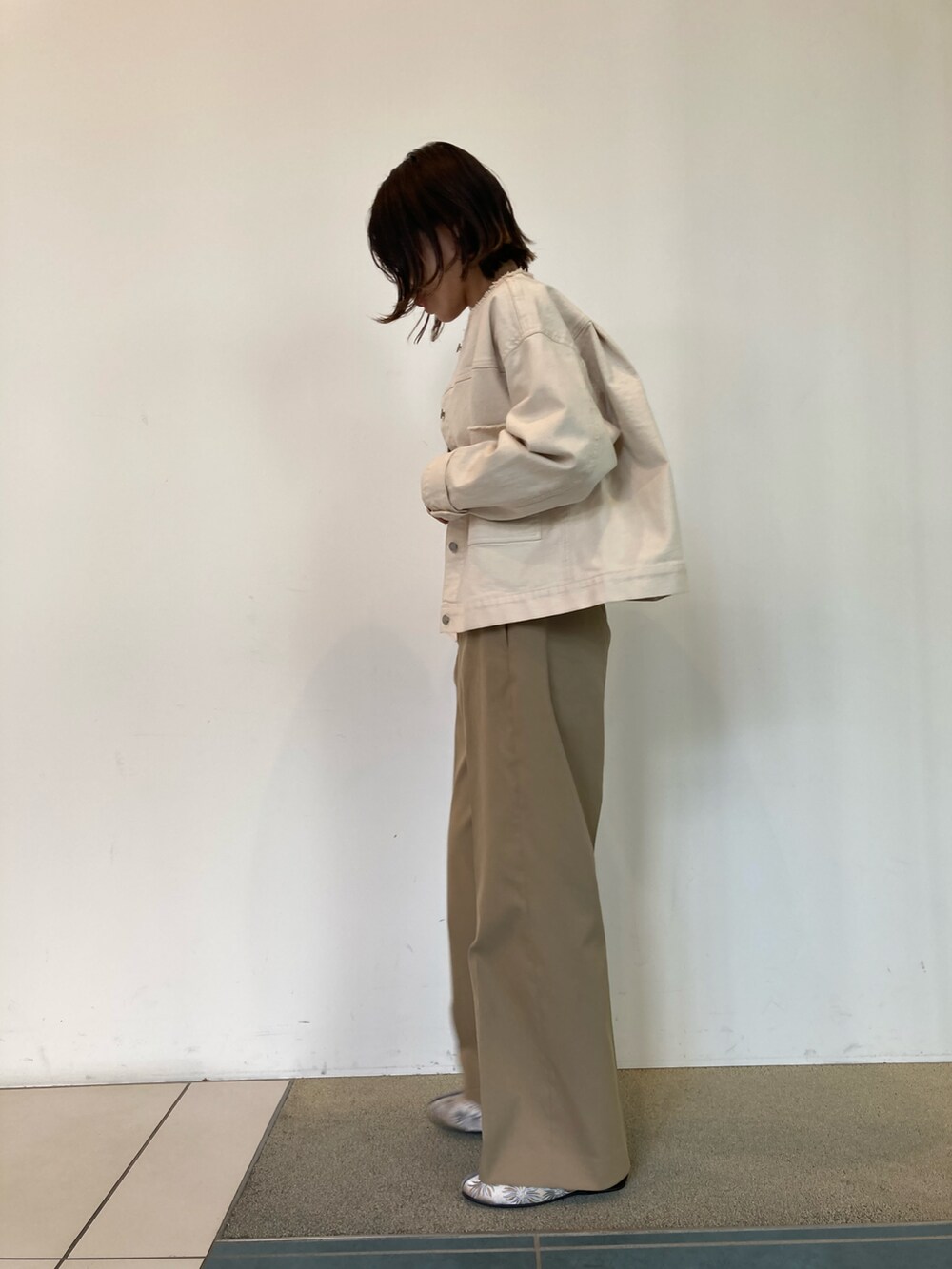 ブラック系のニット/セーター、ホワイト系のブルゾン、ベージュ系のその他パンツを着用したレディースの春コーディネートの2枚目の写真