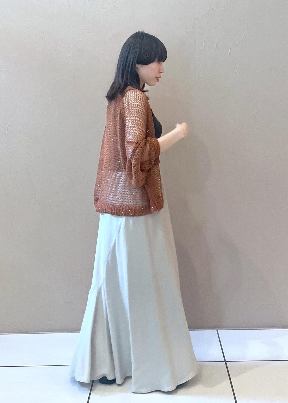 グレー系のタンクトップ、ブラウン系のカーディガン/ボレロ、ベージュ系のスカートを着用したレディースの夏コーディネートの2枚目の写真