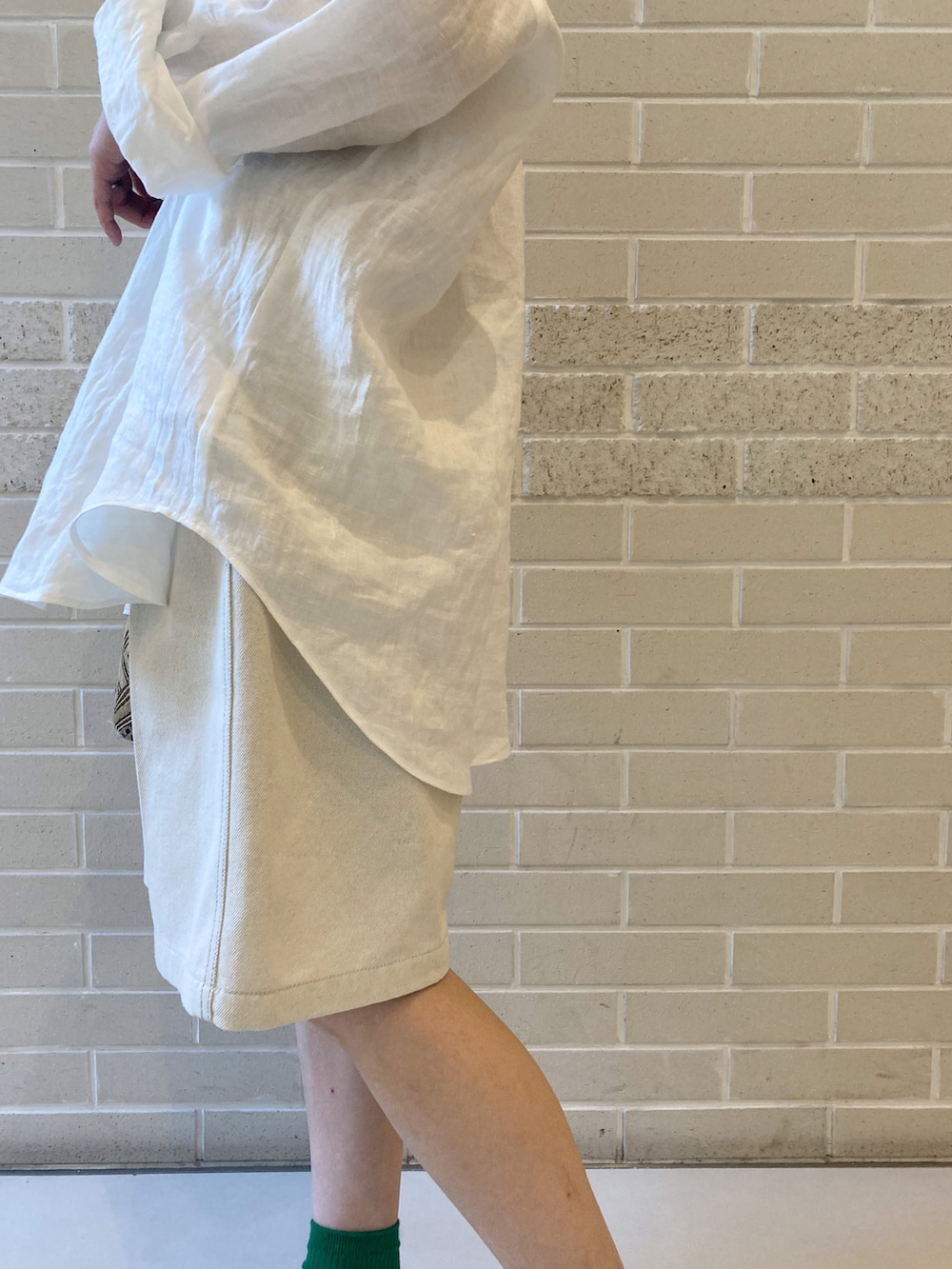 ホワイト系のシャツ/ブラウス、ホワイト系のデニムパンツ、ホワイト系のサンダルを着用したレディースの春コーディネートの4枚目の写真