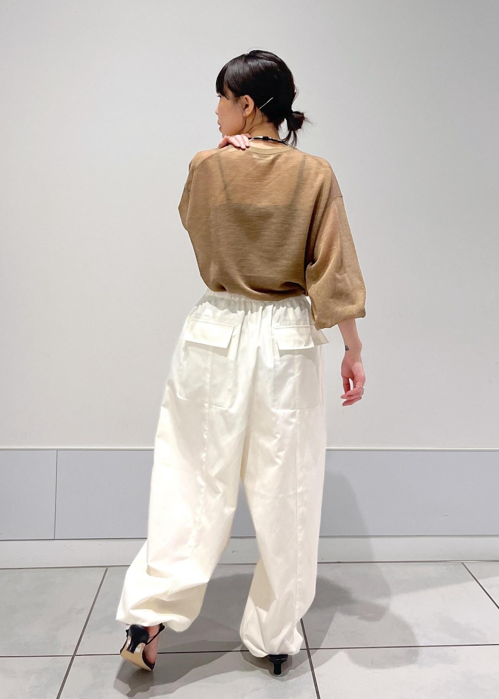 ブラック系のサンダル、ホワイト系のカーゴパンツ、ゴールド系のTシャツ/カットソーを着用したレディースの夏コーディネートの2枚目の写真