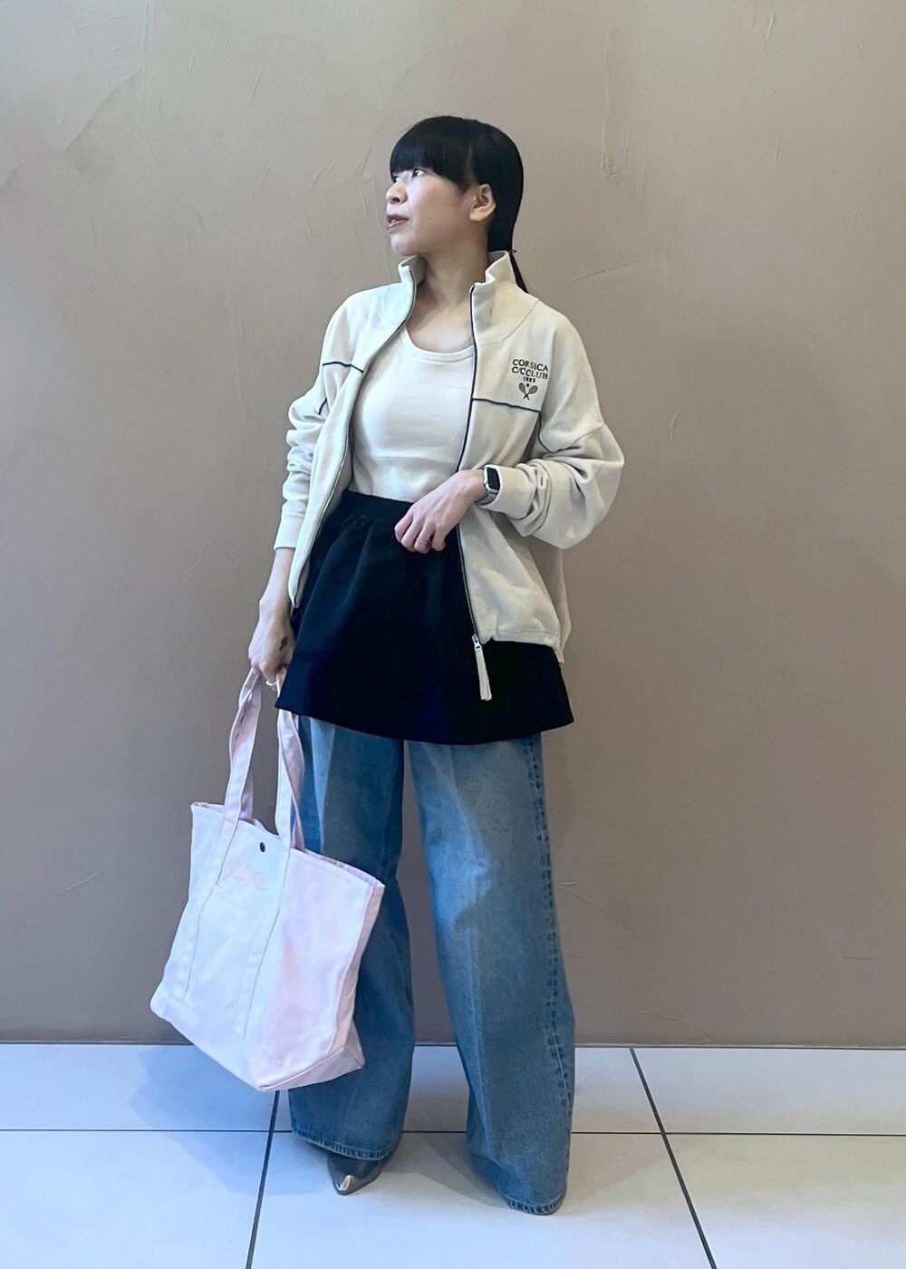 ブルー系のデニムパンツ、ブラック系のスカート、ホワイト系のタンクトップを着用したレディースの冬コーディネートの7枚目の写真