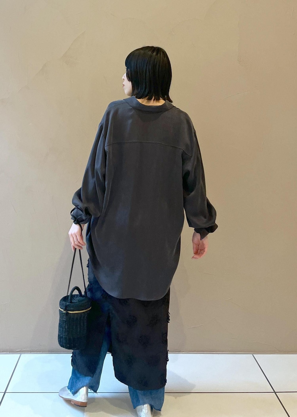 グレー系のシャツ/ブラウス、ブラック系のショルダーバッグ、ブルー系のデニムパンツを着用したレディースの春コーディネートの2枚目の写真