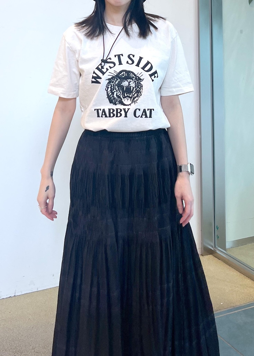 ブラック系のサンダル、ホワイト系のTシャツ/カットソー、ブラック系のスカートを着用したレディースの夏コーディネートの4枚目の写真