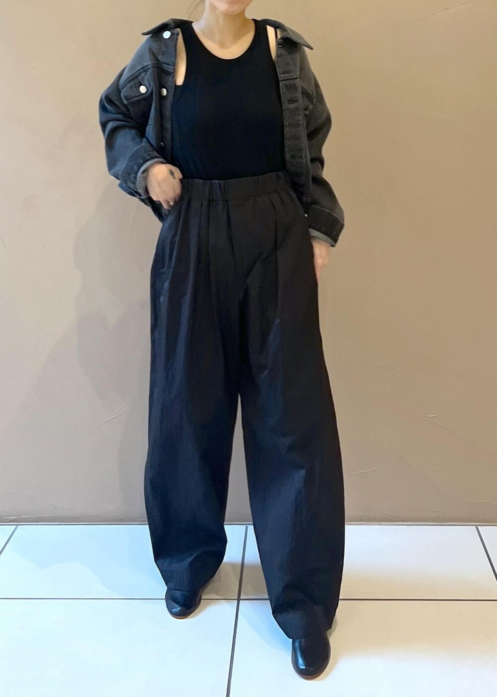 ブラック系のタンクトップ、グレー系のデニムジャケット、ブラック系のその他パンツを着用したレディースの秋コーディネートの6枚目の写真