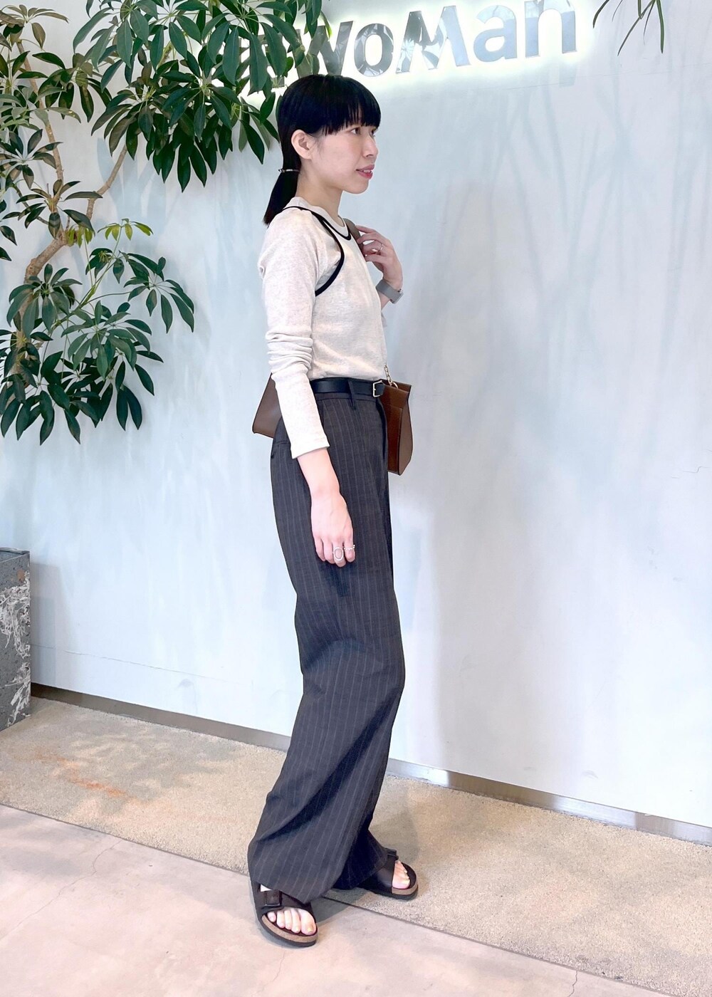 ブラウン系のショルダーバッグ、ベージュ系のタンクトップ、ベージュ系のTシャツ/カットソーを着用したレディースの夏コーディネートの3枚目の写真