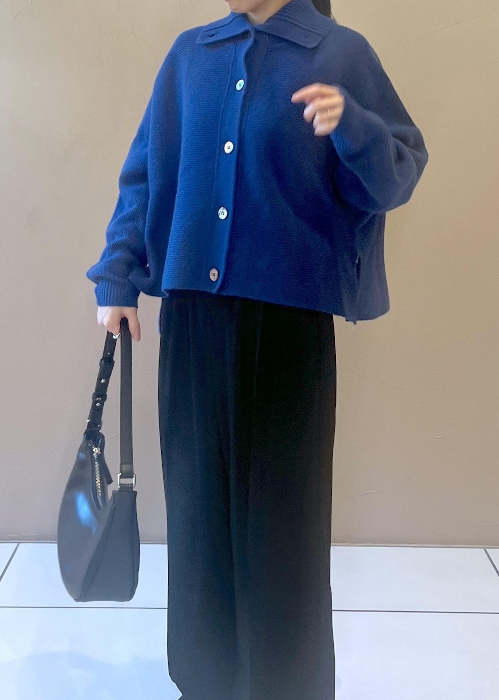 ホワイト系のスニーカー、ブルー系のカーディガン/ボレロ、ブラック系のその他パンツを着用したレディースの秋コーディネートの8枚目の写真
