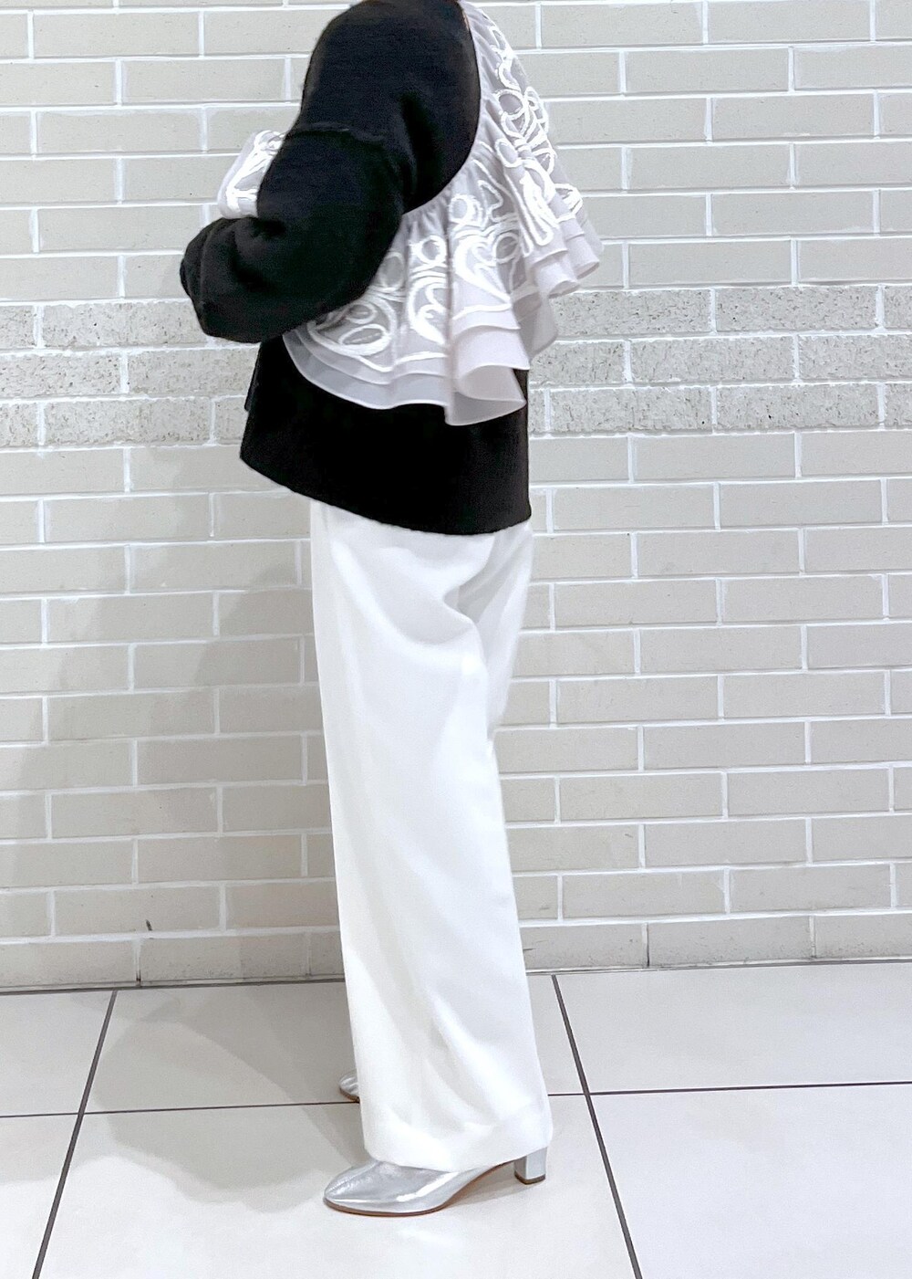 ブラウン系のニット/セーター、ホワイト系のその他パンツ、ベージュ系のストール/ショールを着用したレディースの冬コーディネートの4枚目の写真