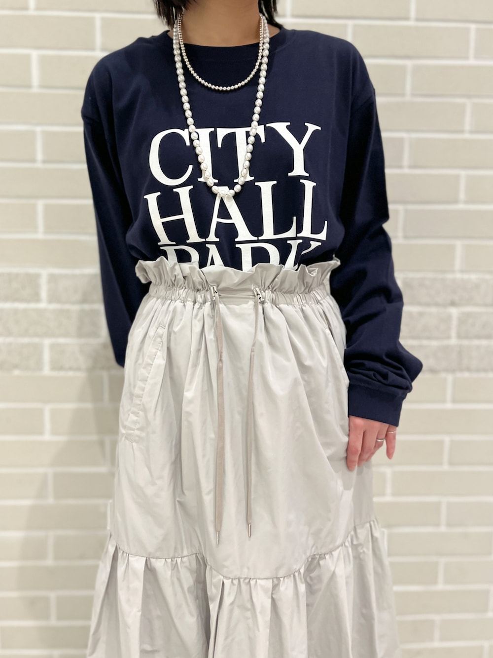 ブルー系のTシャツ/カットソー、グレー系のスカート、グリーン系のスニーカーを着用したレディースの冬コーディネートの4枚目の写真