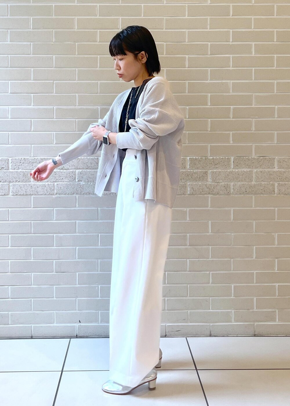 ブラック系のTシャツ/カットソー、ホワイト系のその他パンツ、グレー系のカーディガン/ボレロを着用したレディースの秋コーディネートの4枚目の写真