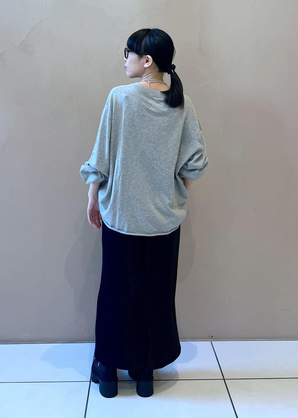 ブラック系のスカート、ブラック系のブーツ、グリーン系のストール/ショールを着用したレディースの冬コーディネートの3枚目の写真