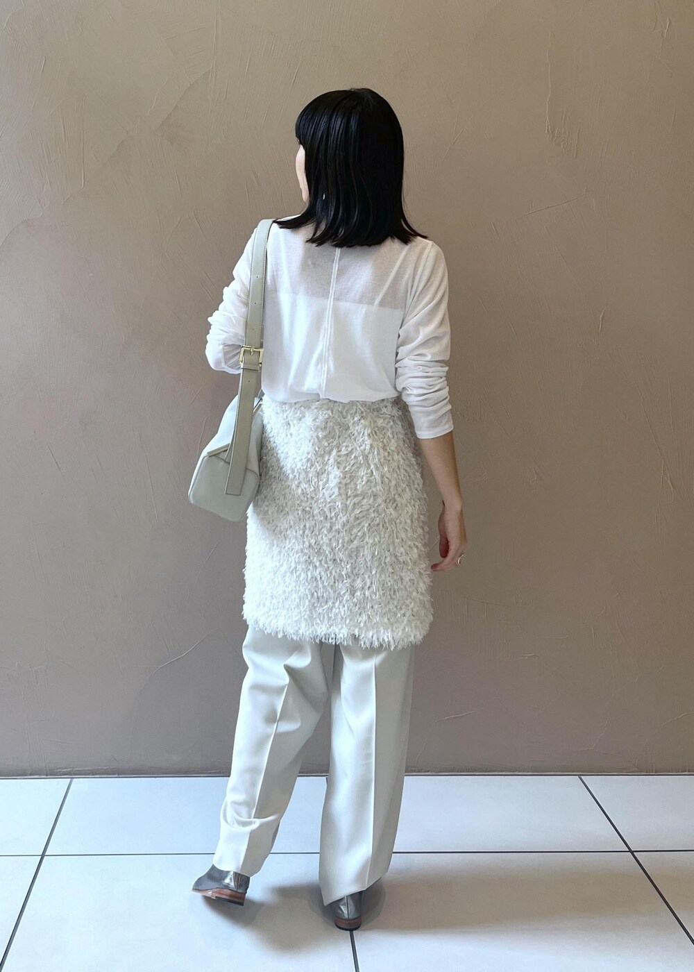 グレー系のショルダーバッグ、ホワイト系のスカート、ベージュ系のその他パンツを着用したレディースの秋コーディネートの5枚目の写真
