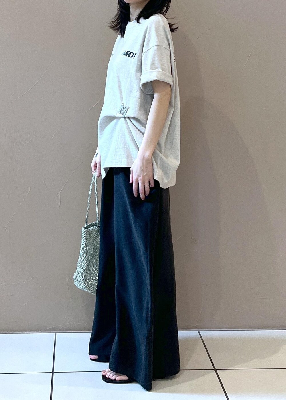 ブラック系のワンピース、ホワイト系のTシャツ/カットソー、シルバー系のトートバッグを着用したレディースの春コーディネートの3枚目の写真