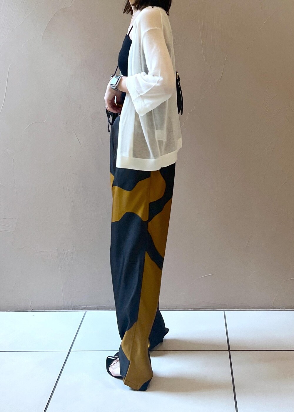 ホワイト系のカーディガン/ボレロ、ブラック系のショルダーバッグを着用したレディースの夏コーディネートの4枚目の写真