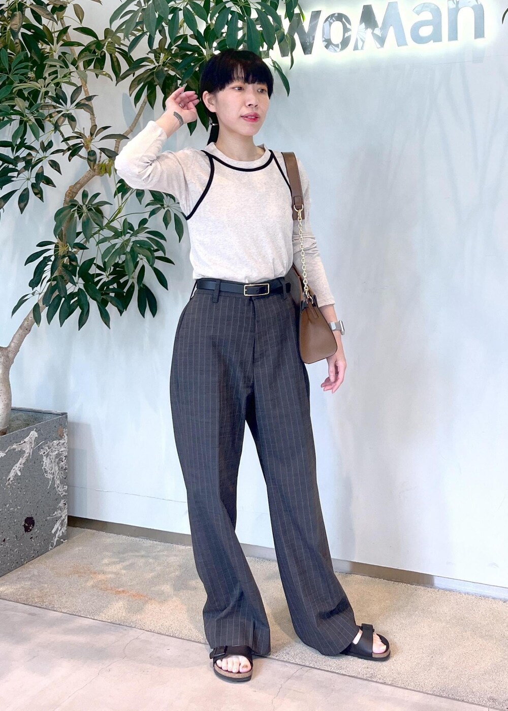 ブラウン系のショルダーバッグ、ベージュ系のタンクトップ、ベージュ系のTシャツ/カットソーを着用したレディースの夏コーディネートの2枚目の写真