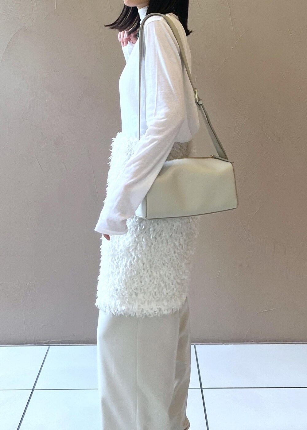 グレー系のショルダーバッグ、ホワイト系のスカート、ベージュ系のその他パンツを着用したレディースの秋コーディネートの8枚目の写真