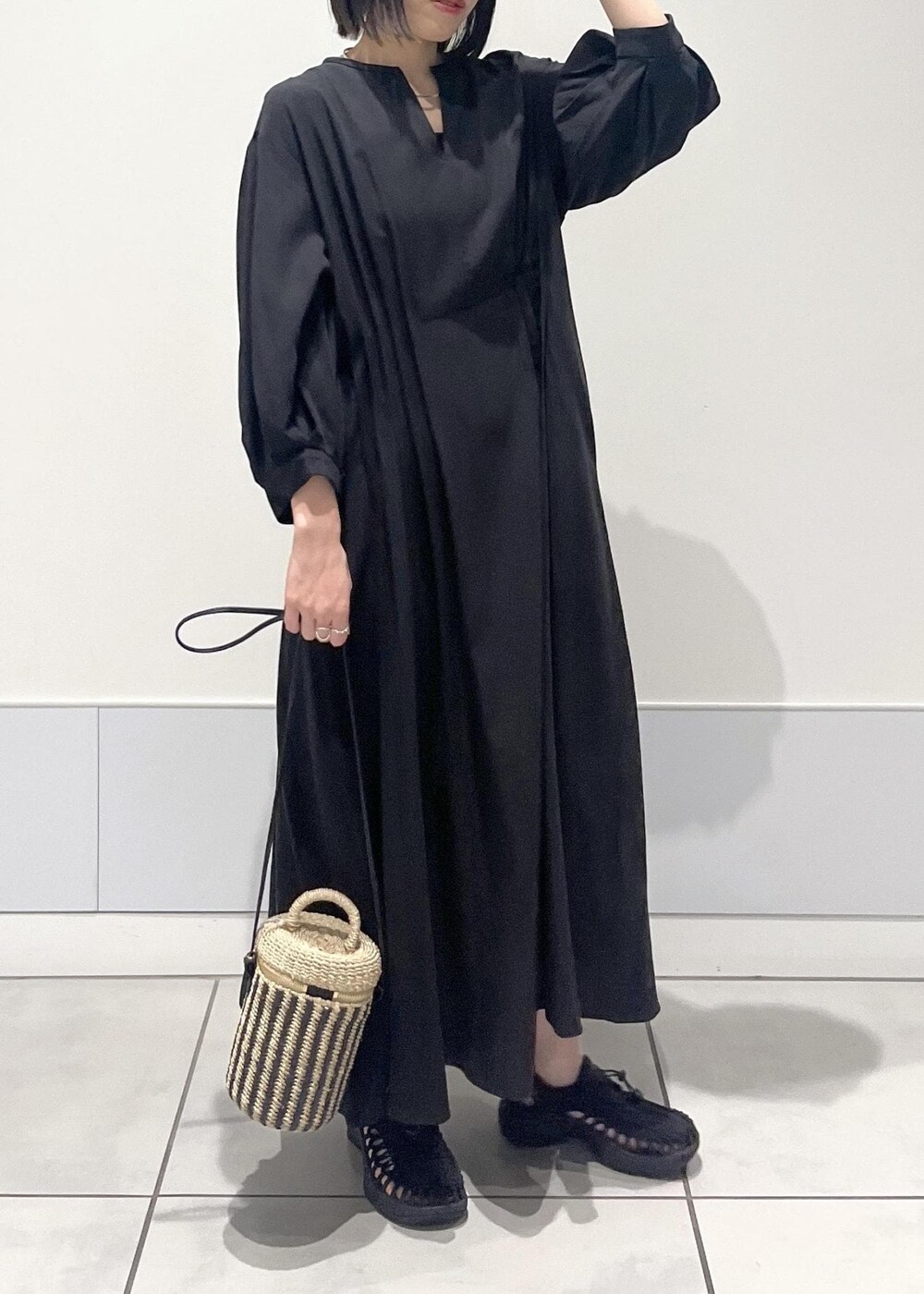 ブラック系のワンピース、ブラック系のサンダル、ホワイト系のショルダーバッグを着用したレディースの春コーディネートの4枚目の写真