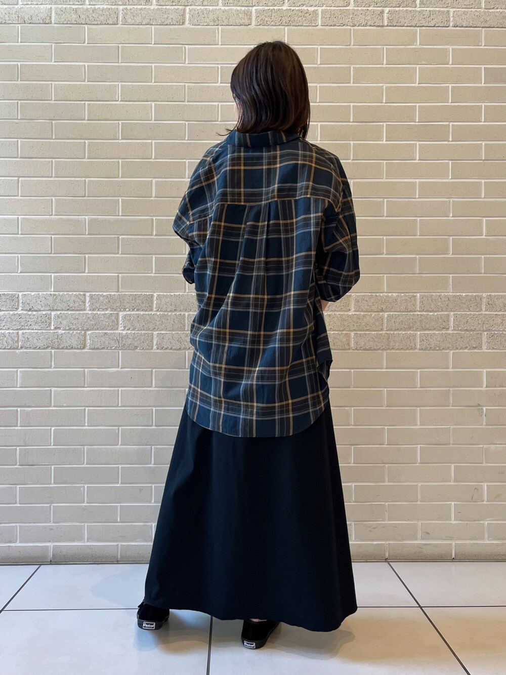ブラック系のワンピース、グレー系のショルダーバッグ、ブラック系のバレエシューズを着用したレディースの夏コーディネートの2枚目の写真