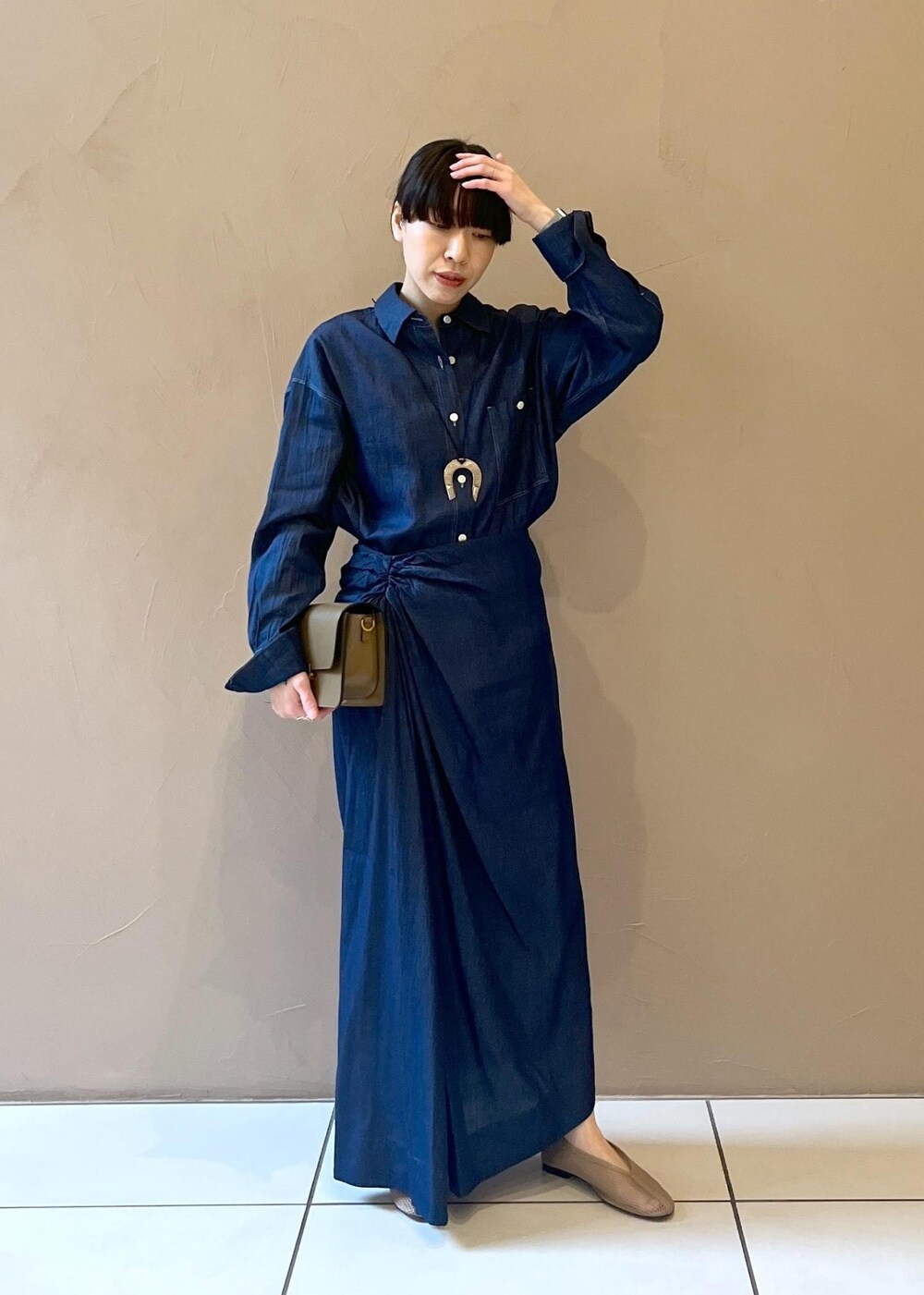 ブラウン系のショルダーバッグ、ベージュ系のパンプス、ブルー系のシャツ/ブラウスを着用したレディースの冬コーディネートの5枚目の写真