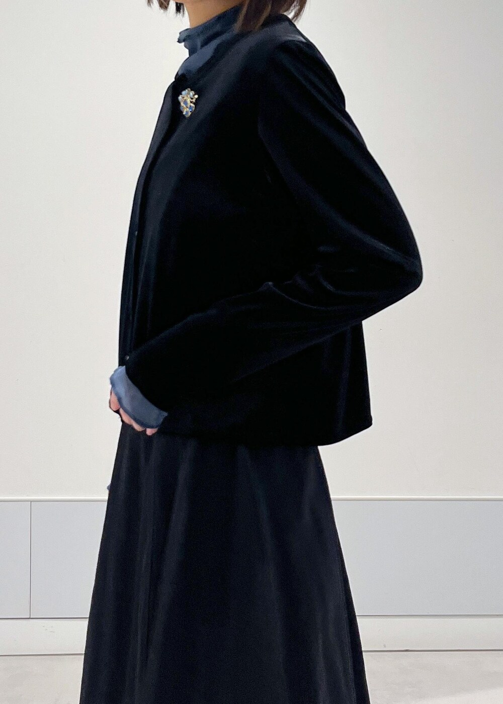 ブルー系のTシャツ/カットソー、ブラック系のスカート、ブラック系のカーディガン/ボレロを着用したレディースの冬コーディネートの5枚目の写真