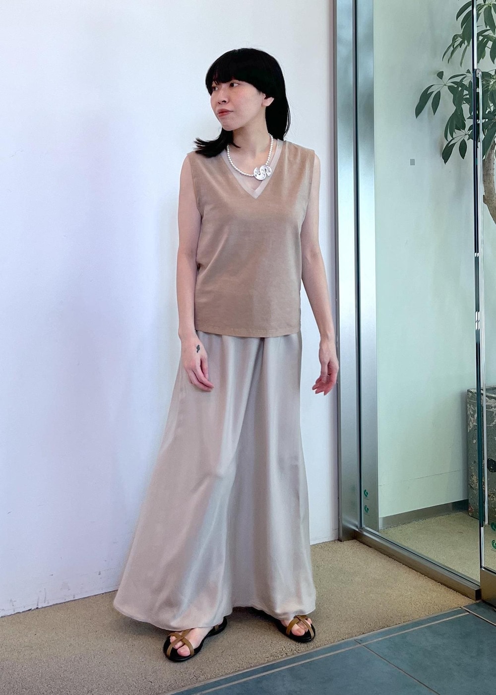ベージュ系のスカート、ベージュ系のタンクトップ、グリーン系のストール/ショールを着用したレディースの夏コーディネートの6枚目の写真