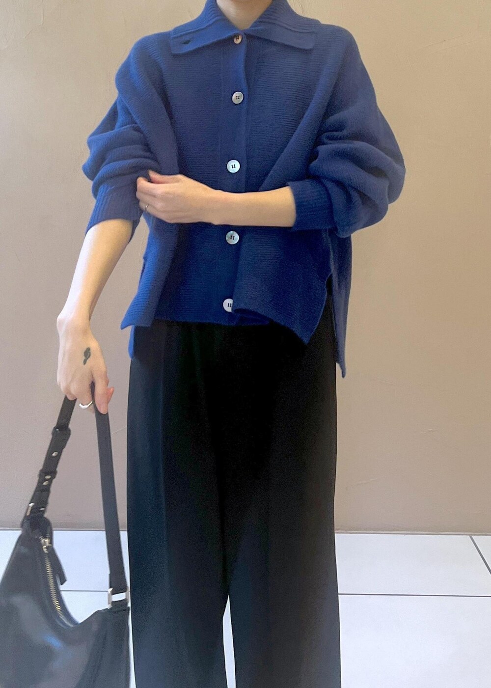 ホワイト系のスニーカー、ブルー系のカーディガン/ボレロ、ブラック系のその他パンツを着用したレディースの秋コーディネートの7枚目の写真