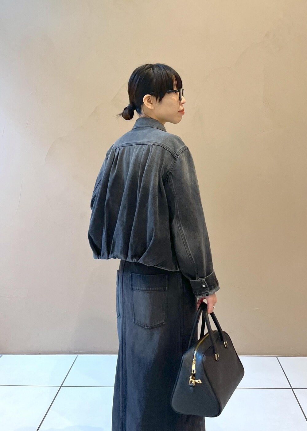 ブラック系のボストンバッグ、グレー系のデニムスカート、グレー系のデニムジャケットを着用したレディースの秋コーディネートの7枚目の写真