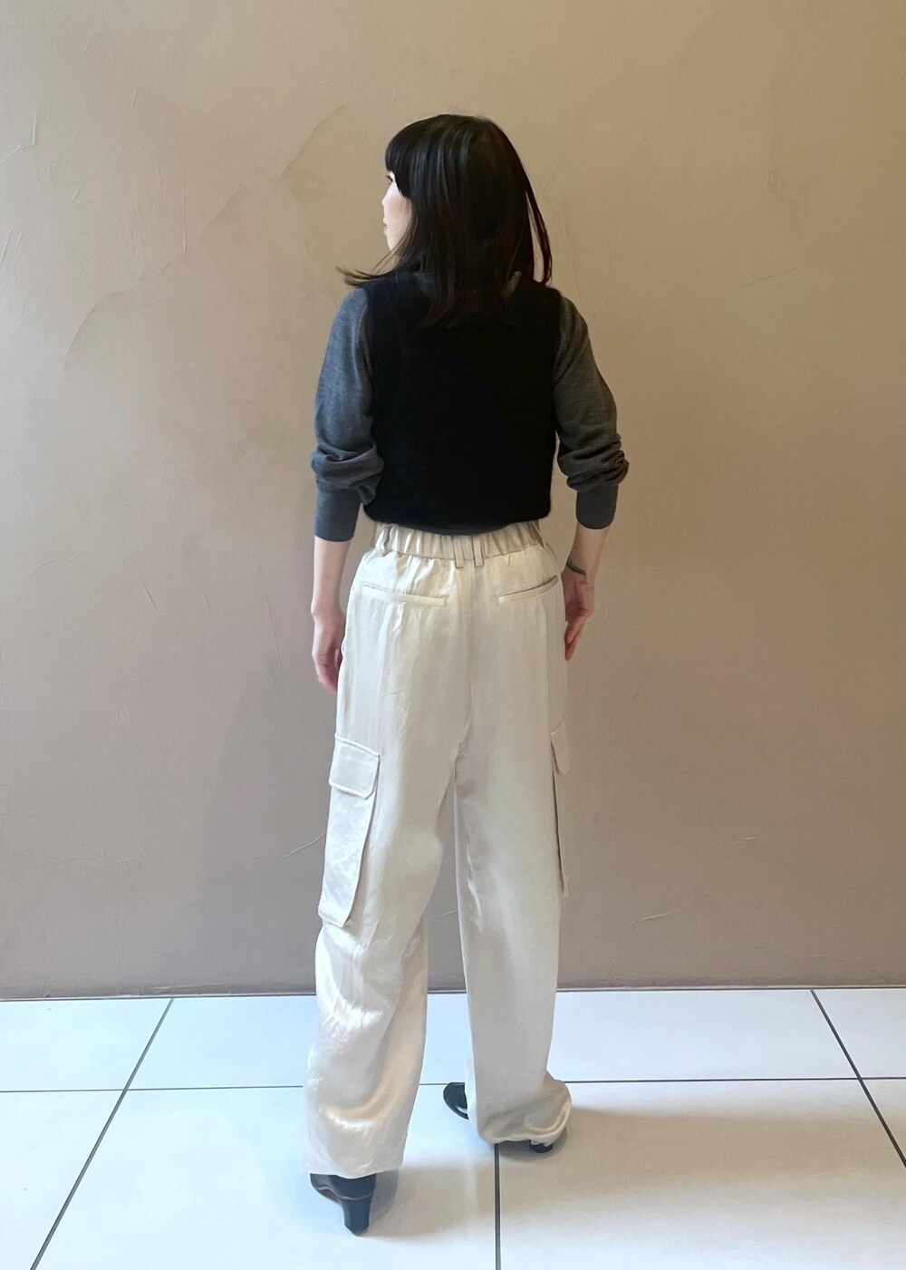 ホワイト系のカーゴパンツ、ブラック系のタンクトップ、グレー系のニット/セーターを着用したレディースの秋コーディネートの3枚目の写真