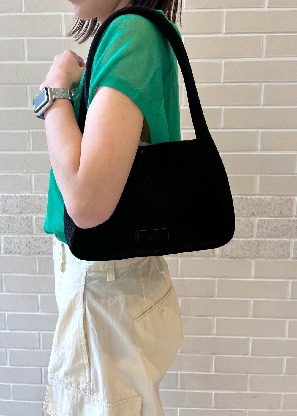 ホワイト系のカーゴパンツ、ホワイト系のチューブトップ、ブラック系のハンドバッグを着用したレディースの春コーディネートの5枚目の写真