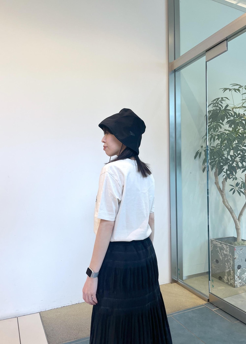 ブラック系のサンダル、ホワイト系のTシャツ/カットソー、ブラック系のスカートを着用したレディースの夏コーディネートの6枚目の写真