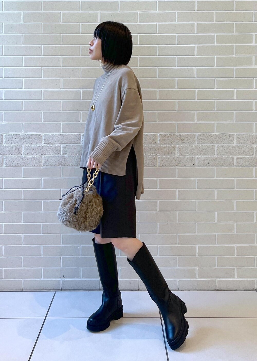 ブラック系のブーツ、グレー系のニット/セーター、グレー系のその他パンツを着用したレディースの秋コーディネートの3枚目の写真