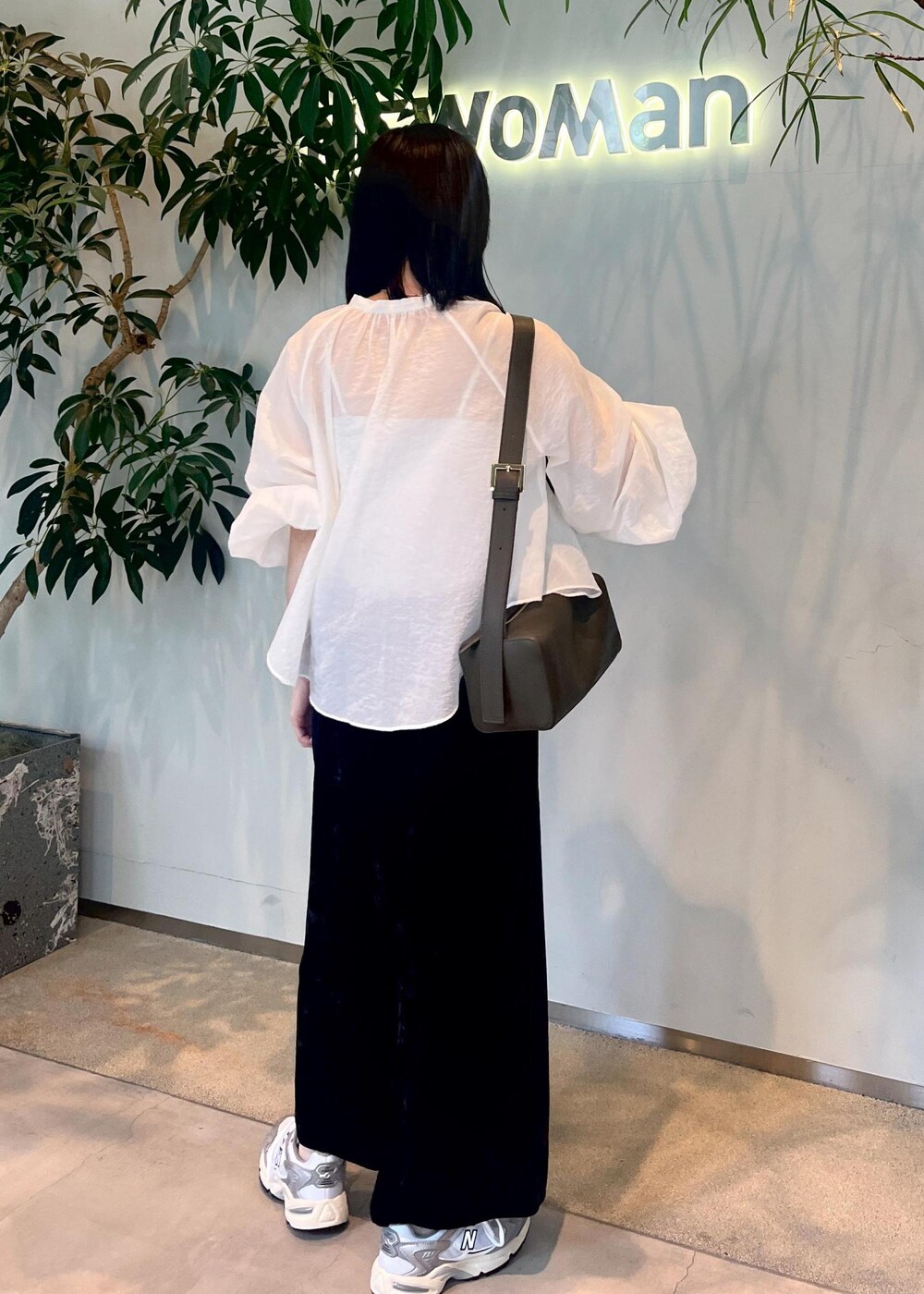 ブラック系のスカート、グリーン系のショルダーバッグ、ホワイト系のシャツ/ブラウスを着用したレディースの夏コーディネートの5枚目の写真