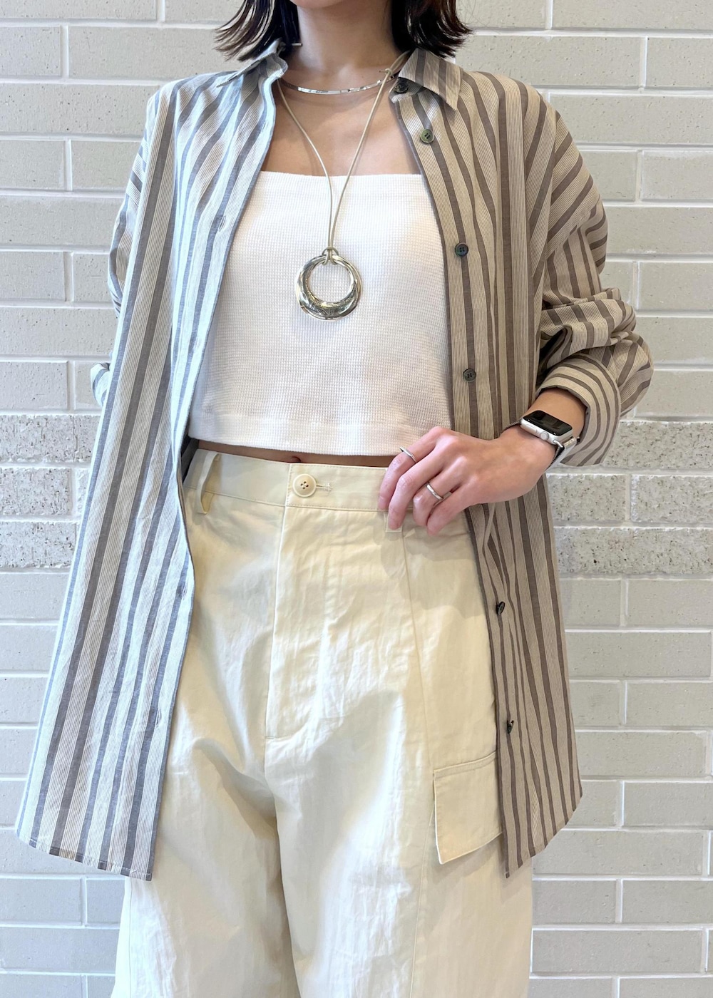 ホワイト系のカーゴパンツ、ブラウン系のサンダル、ホワイト系のチューブトップを着用したレディースの夏コーディネートの3枚目の写真