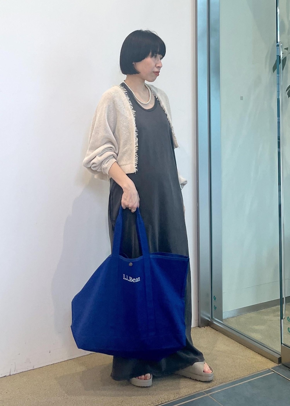 グレー系のワンピース、ホワイト系のカーディガン/ボレロを着用したレディースの夏コーディネートの4枚目の写真